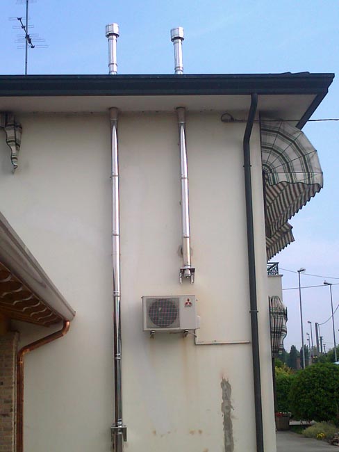Casa moderna, roma italy: smalto per pareti Stufa a pellet in condominio